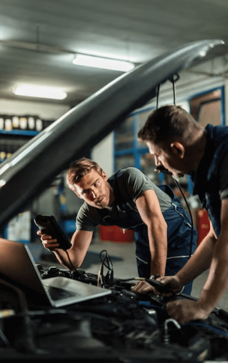 Young car repairman talking with his coworker